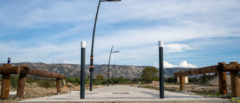 Vue de jour d'une allée pitéone déserte de la ZAC des Hauts Banquets, équipée de lampadaires. En fond, le Luberon